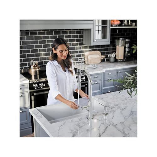 Chrome high-arc kitchen faucet with pull-down sprayer installed on white marble countertop.
