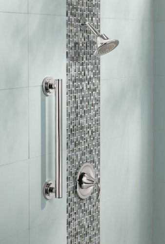 Chrome grab bar mounted vertically on mosaic tile shower wall next to showerhead and controls.
