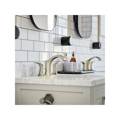Brushed nickel three-hole widespread bathroom faucet with curved spout and lever handles installed on marble countertop.