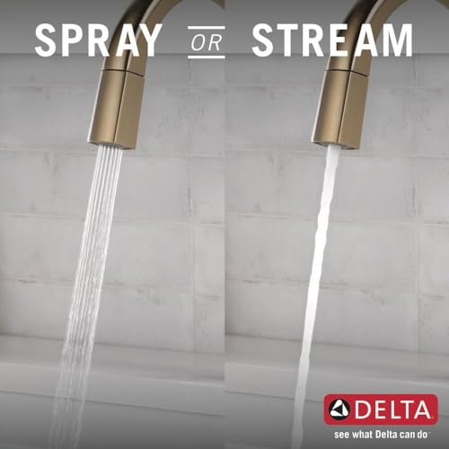 Gold pull-down kitchen faucet demonstrating spray and stream water modes over sink.