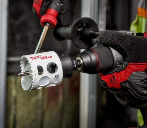 Milwaukee 2-1/2" bi-metal hole saw with white body and black arbor attached to red and black power drill.