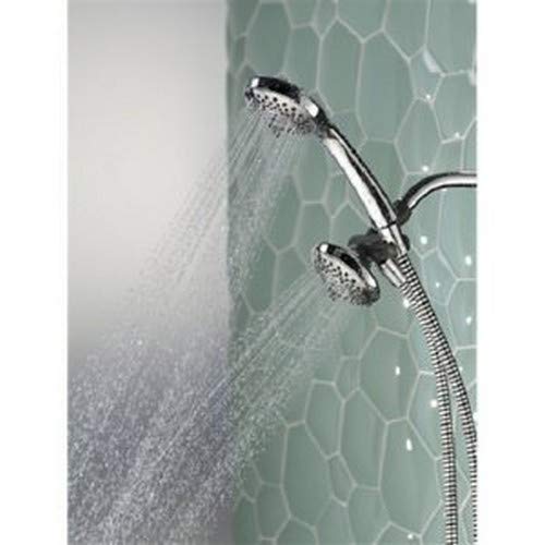 Brushed nickel hand shower and fixed shower head mounted on green tile wall, both spraying water.