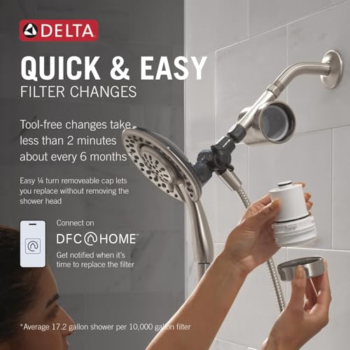 Brushed nickel Delta shower filter attachment with dual showerheads and removable filter cartridge displayed on bathroom wall