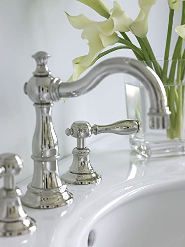 Widespread lavatory faucet with curved spout and lever handles in polished chrome finish installed on white sink.