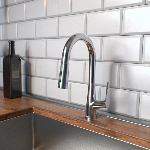 Chrome kitchen faucet with curved spout and pull-down spray head mounted on white subway tile backsplash above sink.
