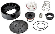 Pressure vacuum breaker repair kit components including black plastic housing parts, white diaphragm discs, metal springs, an