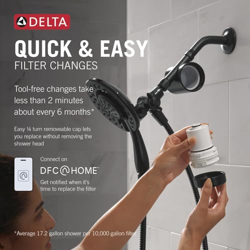 Matte black dual showerhead with detachable filter cartridge being removed by hand during replacement.