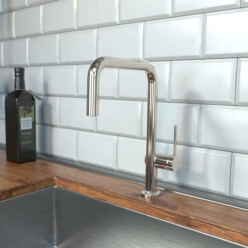 Polished nickel U-shaped kitchen faucet with single spray handle mounted on wooden countertop against white subway tile backs