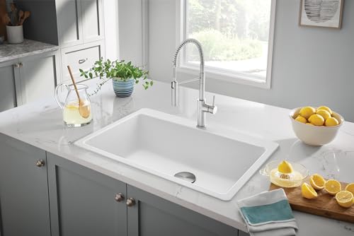 White single bowl drop-in kitchen sink with chrome pull-down faucet installed in gray cabinetry.
