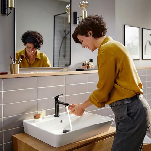 Chrome single-hole bathroom faucet with tall curved spout and black handle on white rectangular sink.