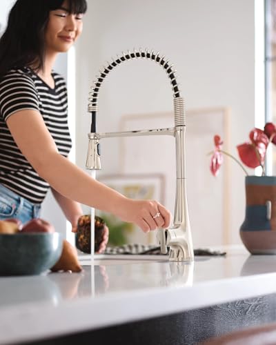 Polished nickel high-arc kitchen faucet with pulldown sprayer and sensor activation displayed on countertop.