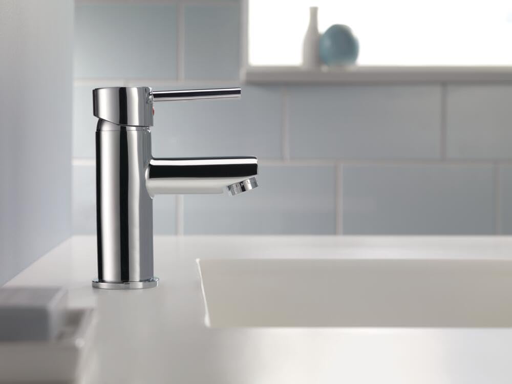 Chrome single-handle bathroom faucet with cylindrical body and curved spout mounted on white sink.