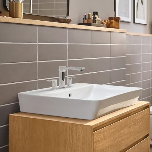 Chrome widespread bathroom faucet with rectangular handles mounted on white rectangular sink above wooden vanity.