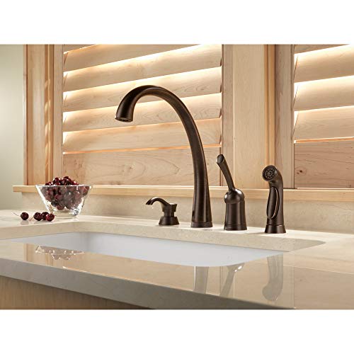 Venetian bronze soap and lotion dispenser with curved spout mounted on bathroom sink countertop.