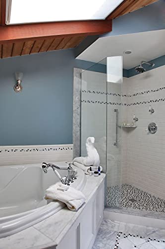 Chrome 4-hole deck mount tub filler with curved spout and dual handles installed on white bathtub surround.