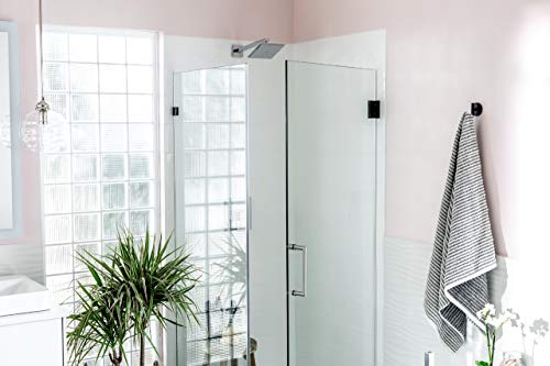Polished nickel robe hook mounted on white bathroom wall next to glass shower enclosure.