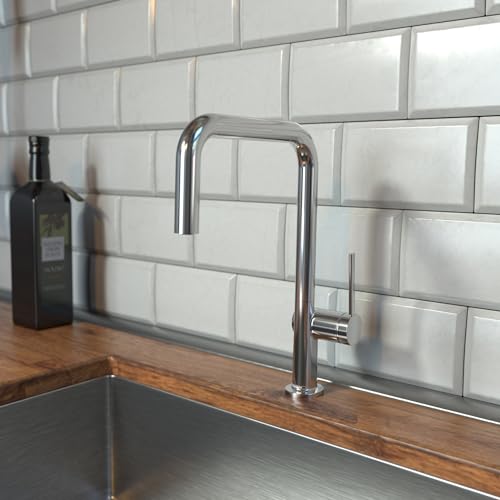 Chrome U-shaped kitchen faucet with single spray head mounted on wooden countertop against white subway tile backsplash.
