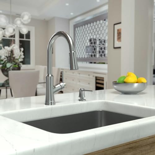 Chrome kitchen faucet with high arc spout and pull-down spray head installed above white undermount sink.