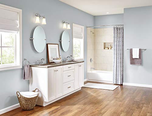 Chrome two-handle bathroom faucet with single spout mounted on white vanity sink.