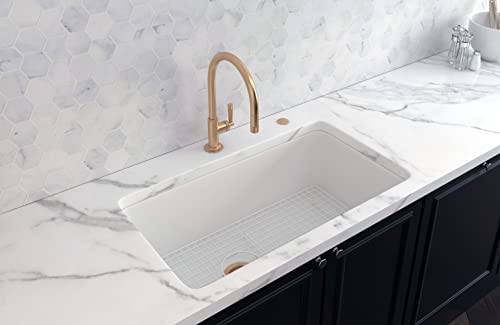 Stainless steel wire grid sink protector with rectangular grid pattern, positioned in white kitchen sink basin.