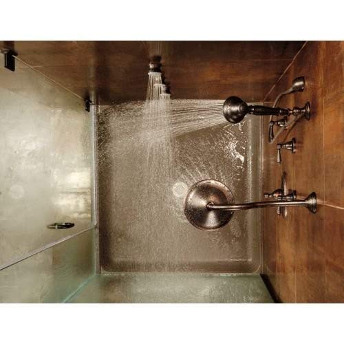 Stainless steel shower flange with circular trim ring and dual lever handles mounted on tile wall with active water spray.