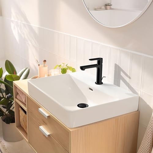 Matte black single-hole bathroom faucet with lever handle mounted on white rectangular sink in modern vanity setting.