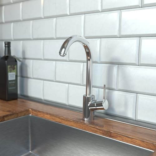 Chrome pull-down kitchen faucet with curved spout mounted on white subway tile backsplash above sink.