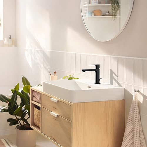 Matte black single-hole bathroom faucet with curved spout mounted on white rectangular sink basin.
