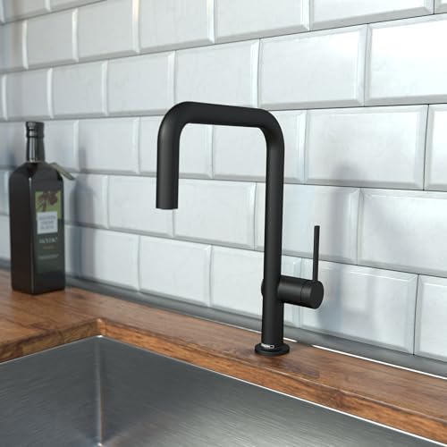 Matte black U-shaped kitchen faucet with single spray handle mounted on countertop against white subway tile backsplash.