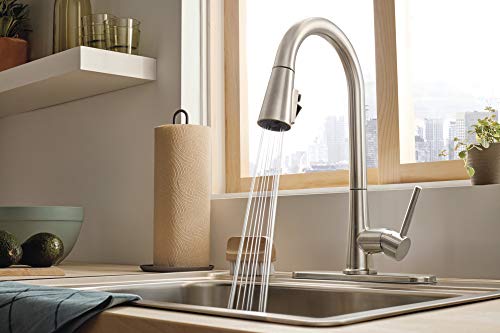 Stainless steel single-handle pull-down kitchen faucet with curved spout over sink.
