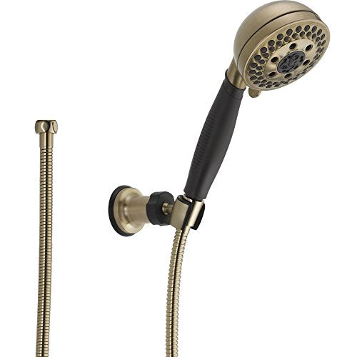 Brushed gold hand shower with black grip, wall mount bracket, and flexible hose connection.