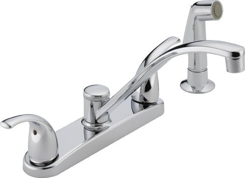 Chrome two-handle kitchen faucet with curved spout, separate sprayer, and dual control knobs.
