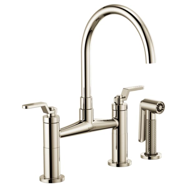 Chrome bridge faucet with curved arc spout, dual lever handles, and side sprayer.