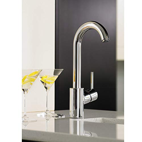 Chrome bar faucet with curved spout and single lever handle on countertop.