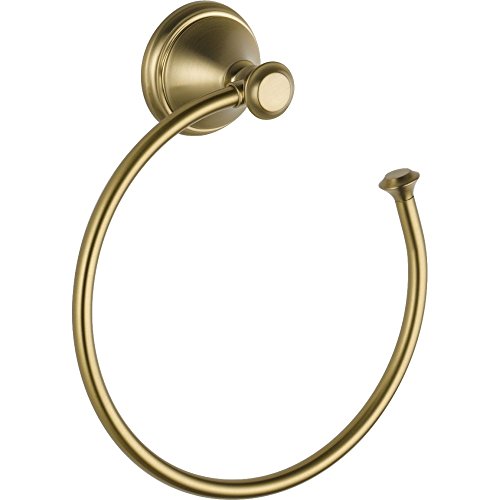 Brass-tone circular towel ring with wall-mounted decorative fixture and knob closure.