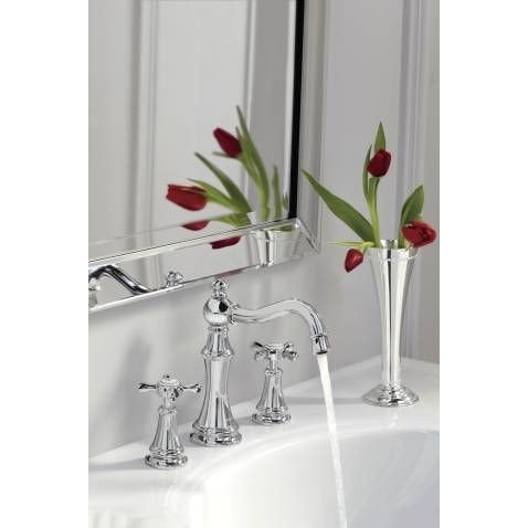Polished nickel widespread bathroom faucet with cross handles and curved spout installed on white sink.