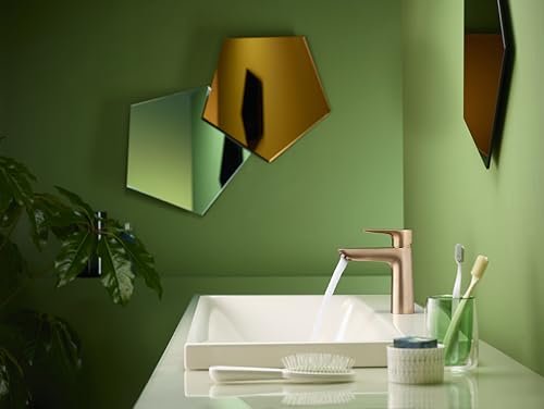 Brushed bronze single-hole faucet with lever handle installed above white rectangular sink on green wall.