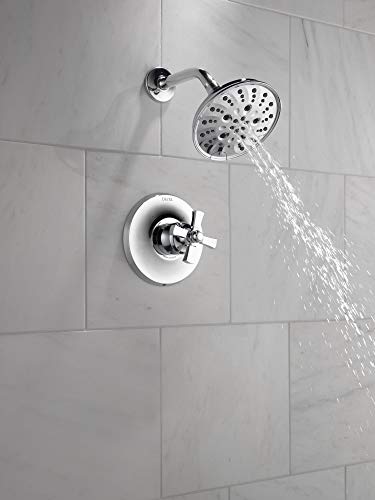 Chrome shower trim with single handle control and multi-spray showerhead mounted on white tile wall.