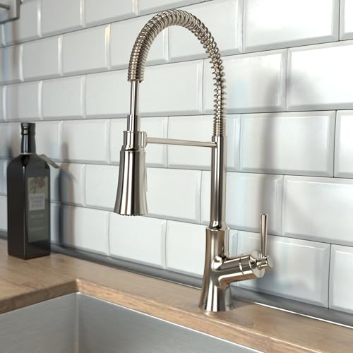 Polished nickel semi-pro kitchen faucet with coiled spray hose and single lever handle mounted on white subway tile backsplas