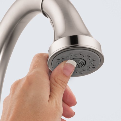 Hand holding brushed gold high-arc kitchen faucet with pull-down spray head and multiple spray settings.
