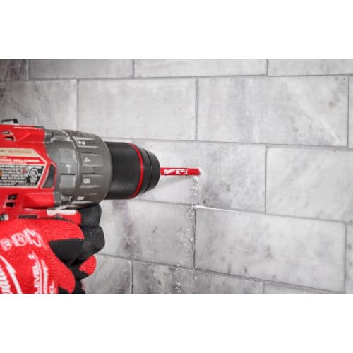 Two Milwaukee diamond grit hole saws with 1/4 inch diameter bits attached to red power drill against tile wall.
