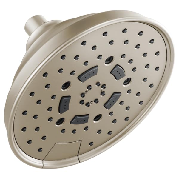 Round brushed nickel shower head with multiple spray holes and dark gray function selectors on face.