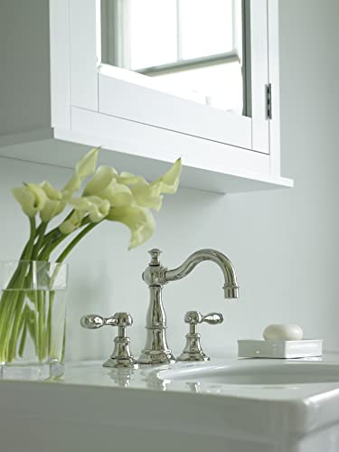Antique brass three-hole widespread bathroom faucet with curved spout and lever handles on white sink.