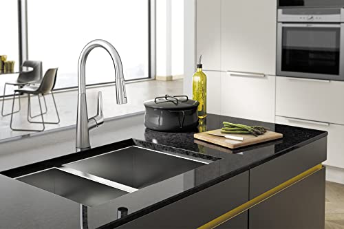 Polished nickel high-arc kitchen faucet with pull-down sprayer installed over black sink in modern kitchen.