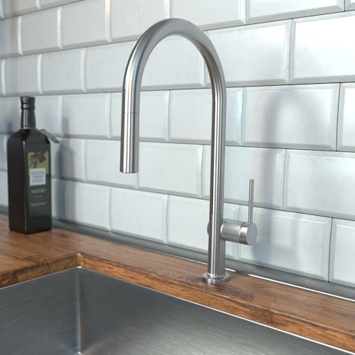 Steel Optic high arc kitchen faucet with pull-down spray head mounted on wooden countertop against subway tile backsplash.