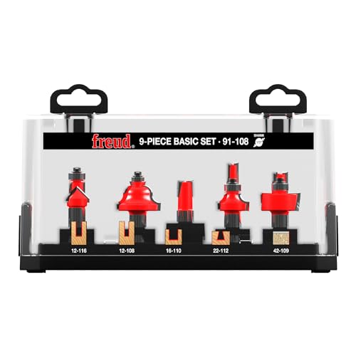 Nine router bits with red cutting heads and tan shanks displayed in a black plastic case with Freud branding.