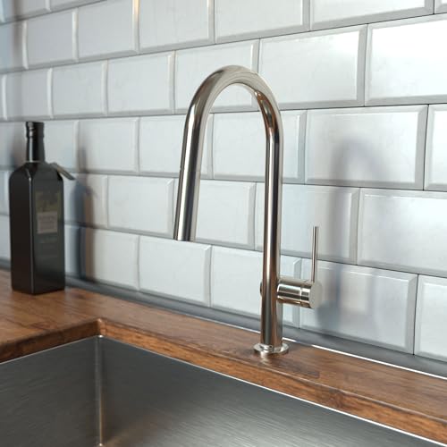 Polished nickel high-arc kitchen faucet with pull-down spray mounted on wooden countertop against white subway tile backsplas