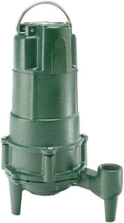 Green cast iron grinder pump with handle, discharge port on side, and cylindrical body with ribbed sections.
