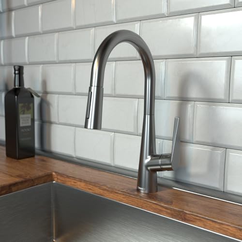 Brushed black chrome high arc kitchen faucet with pull-down sprayer mounted on wooden countertop against white subway tile ba