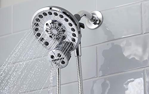 Chrome shower head with multiple spray jets mounted on wall with attached hose and white subway tile background.